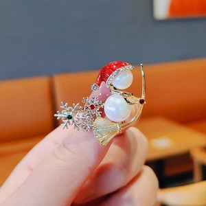 Detail of a pearl snowman brooch with colorful rhinestones and gold snowflake