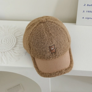 Detail of winter sherpa baseball cap with bear embroidery and corduroy brim texture