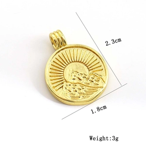 Golden sun and mountain relief pendant with brushed metal texture on white background