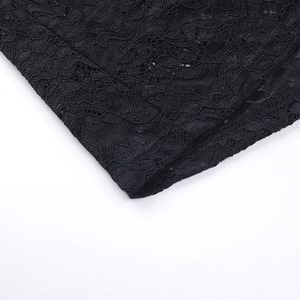 Close-up of black lace fabric showing intricate floral patterns and fine stitching detail