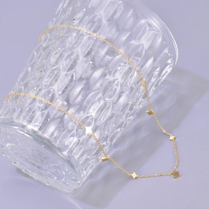 18K gold plated stainless steel necklace with delicate star charms draped on glass