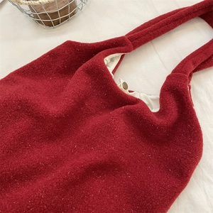 Detail view of red felt tote bag with soft cotton lining and metallic snap button