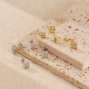 Detailed view of S925 silver four-leaf clover earrings with zircon in gold and silver