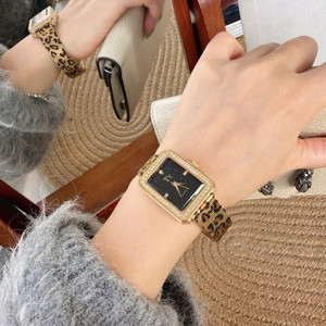 Detail of rectangular gold leopard print watch with diamond bezel and starlight dial