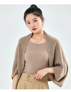 Detail of a brown knitted cashmere shawl over a beige ribbed top for women's autumn style
