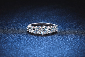 Macro shot of five round D color moissanite stones set in a sterling silver ring