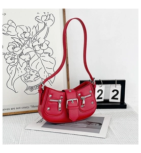 Detail of red Y2K semi-circle bag with silver studs and decorative buckle elements