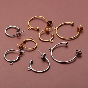 Detailed macro of C-shaped stainless steel earring posts in gold and silver finish