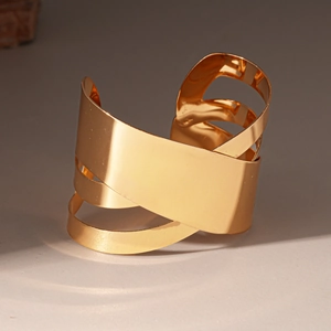 Détail d'un bracelet manchette doré multicouche poli au design géométrique irrégulier