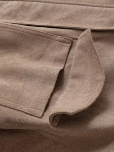 Nahaufnahme der tanfarbenen Wildleder-Textur mit großer Pattentasche an einer Streetwear-Jacke