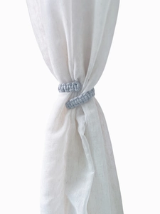 Detail of light blue handmade cotton rope curtain tieback with woven texture design