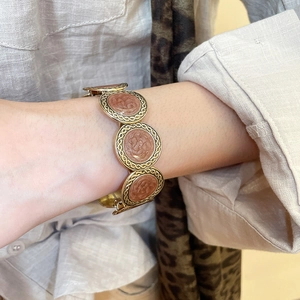 Close-up of vintage leopard print resin bracelet with antique gold braided metal trim