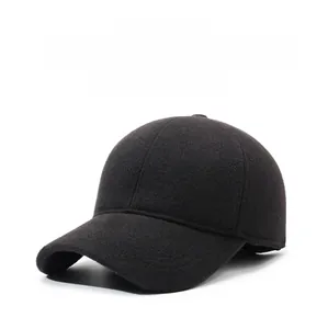 Detail view of winter baseball cap with ear flaps and metallic SPORT emblem on black wool fabric