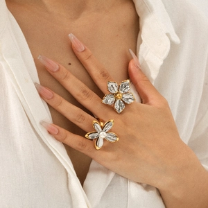 Two-tone gold and silver flower open ring with transparent petals on female hand