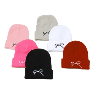 Set of six colorful knit beanies with minimalist bow embroidery for winter warmth