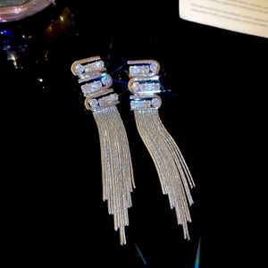 Close-up of silver tassel earrings featuring zircon inlay and elegant long metal chains