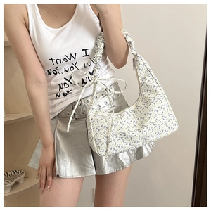 Detail of floral hobo bag with pleated cloud strap and delicate ribbon bow accessory