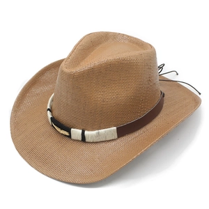 Close-up of western straw cowboy hat featuring a golden feather metal buckle and leather band