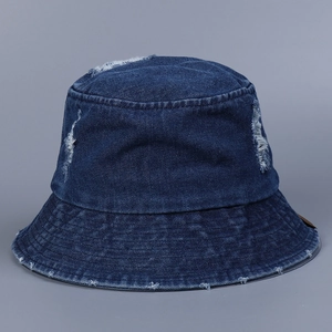 Vue détaillée d'un chapeau bob en jean bleu foncé délavé avec bords effilochés et trous
