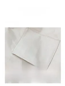 Detailed close-up showing the front storage pocket of a white canvas tote bag with a phone inside
