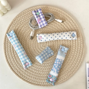 Macro detail of fabric cable organizers in plaid and floral patterns with snap buttons