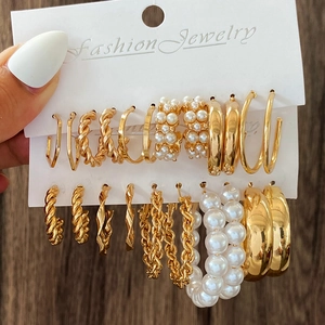 Golden alloy hoop earring set with assorted geometric rings and faux pearls on display