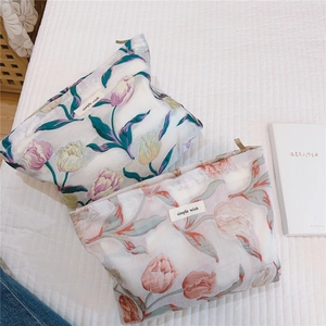 Détail de trousses à maquillage en jacquard tulipe avec fermetures dorées