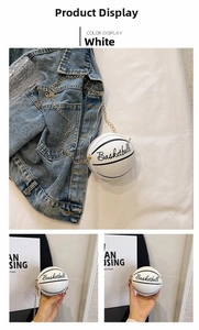 Detail shot of a white basketball-shaped mini bag with golden chain and artistic lettering