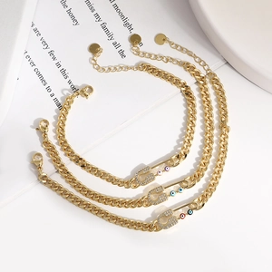 Detail of gold evil eye paperclip bracelets with pavé zircons and adjustable chain link