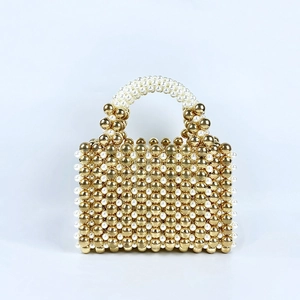 Detail of handcrafted gold and white pearl beaded handbag with metallic beads