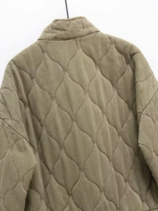 Close-up of wavy quilted pattern and durable fabric texture on khaki puffer jacket