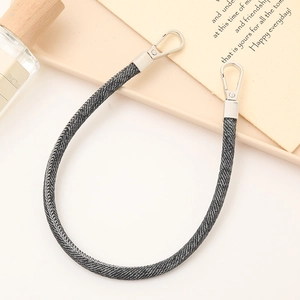 Close-up of a grey denim fabric phone wrist strap with dual silver metal lobster clasps