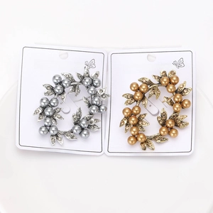 Detailed macro view of gold and silver wreath brooches with pearls and rhinestones