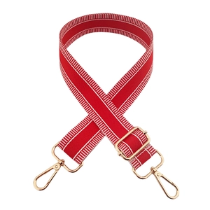 Detail of red and white striped fabric bag strap with adjustable gold metal buckles