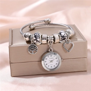 Silver beaded bracelet watch with heart and tree charms on elegant pink silk cloth