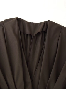 Detail of high-quality stitching and smooth dark brown fabric texture on the neckline