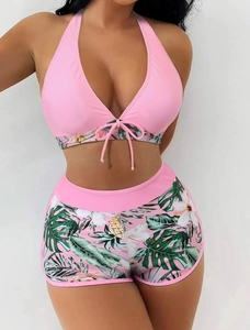 Detailed view of pink halter bikini top with tropical floral high-waisted shorts