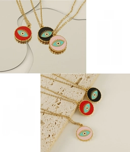Detail of evil eye pendants in red, black, and pink enamel on a golden steel chain