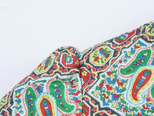 Close-up of ethnic paisley print fabric and double-stitched seams on cotton coat