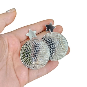 Close-up of silver mirror disco ball earrings with star studs on a hand palm