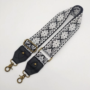 Adjustable woven canvas bag strap with black and white geometric patterns and bronze hooks
