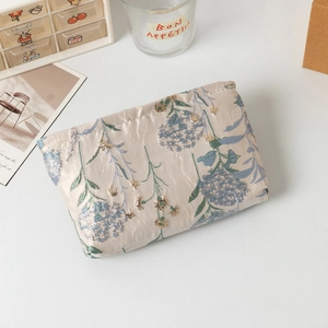 Dettaglio della borsa trucco jacquard con motivi floreali e filo di seta dorato