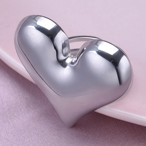 Detail of 304 stainless steel heart ring with polished silver finish on a pink plate