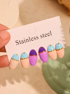 Detail of color-blocked oval press-on nails in purple and blue with dotted texture