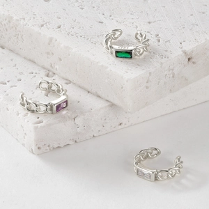 Macro shot of S925 sterling silver ear cuffs with green, purple and white gemstones