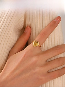 Detailed close-up of a 18K gold plated heart ring with elegant beaded edge on a finger