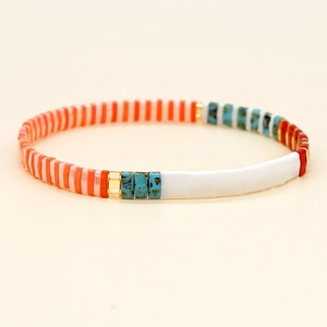 Bohemian Tila bead bracelet with colorful rainbow enamel and gold beads on beige background