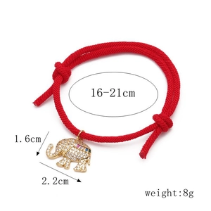 Detail showing adjustable red rope bracelet with gold elephant charm and zircons