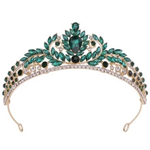 Macro detail of luxury bridal crown with emerald green crystals and gold finish
