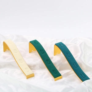 Detailed view of beige and green velvet jewelry display stands with gold metal bases
